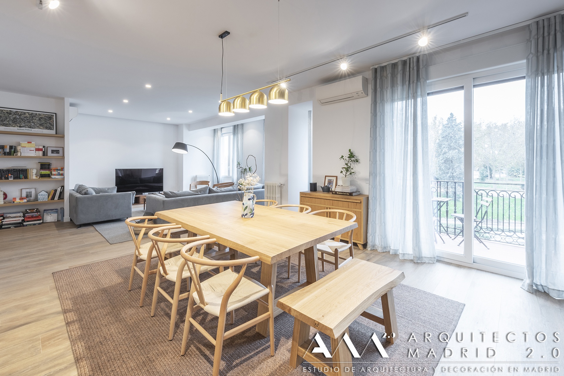 Comedor de Ferraz con mesa de madera, salón al fondo y puertas acristaladas hacia los balcones.