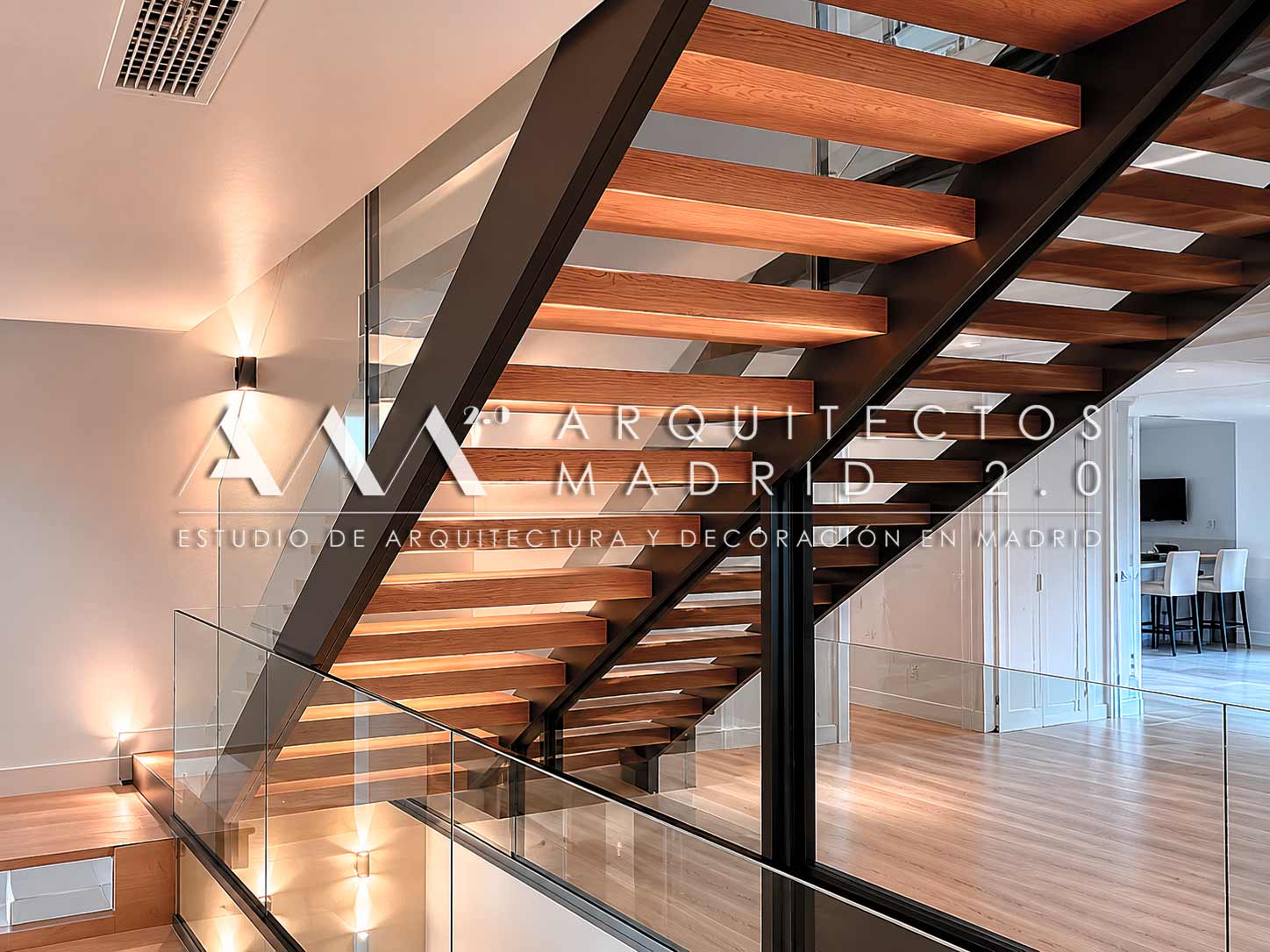 Escalera interior de madera, metal y vidrio en un chalet reformado en Las Rozas