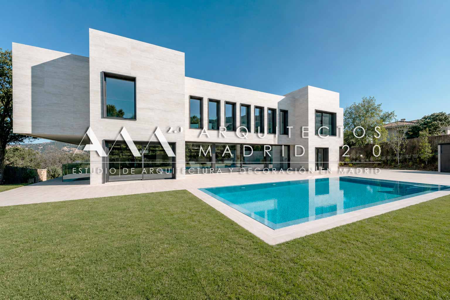 Vivienda unifamiliar contemporánea implantada junto a una piscina lateral, con jardín y distintos planos de fachada
