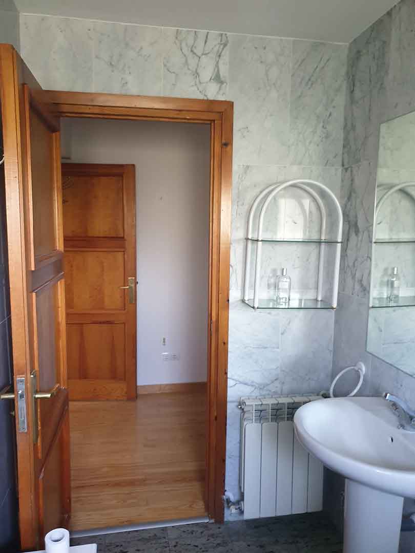 Baño previo con revestimientos e instalaciones antes de la reforma integral del chalet