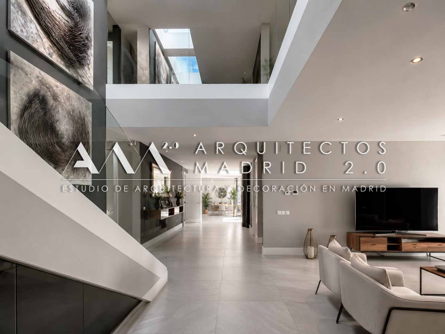Vestíbulo de doble altura y escalera interior de una vivienda unifamiliar en Boadilla del Monte