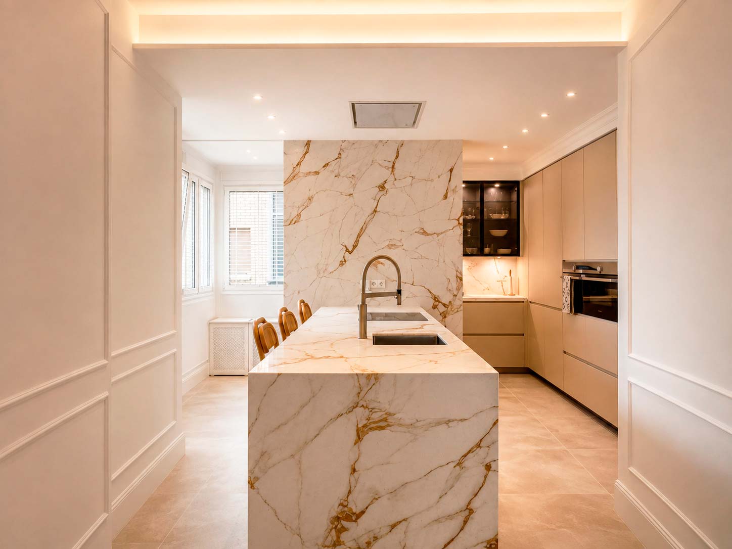 Cocina diseñada a medida con gran isla y encimera porcelánica XTONE de Porcelanosa en la reforma integral de Fuencarral, Chamberí