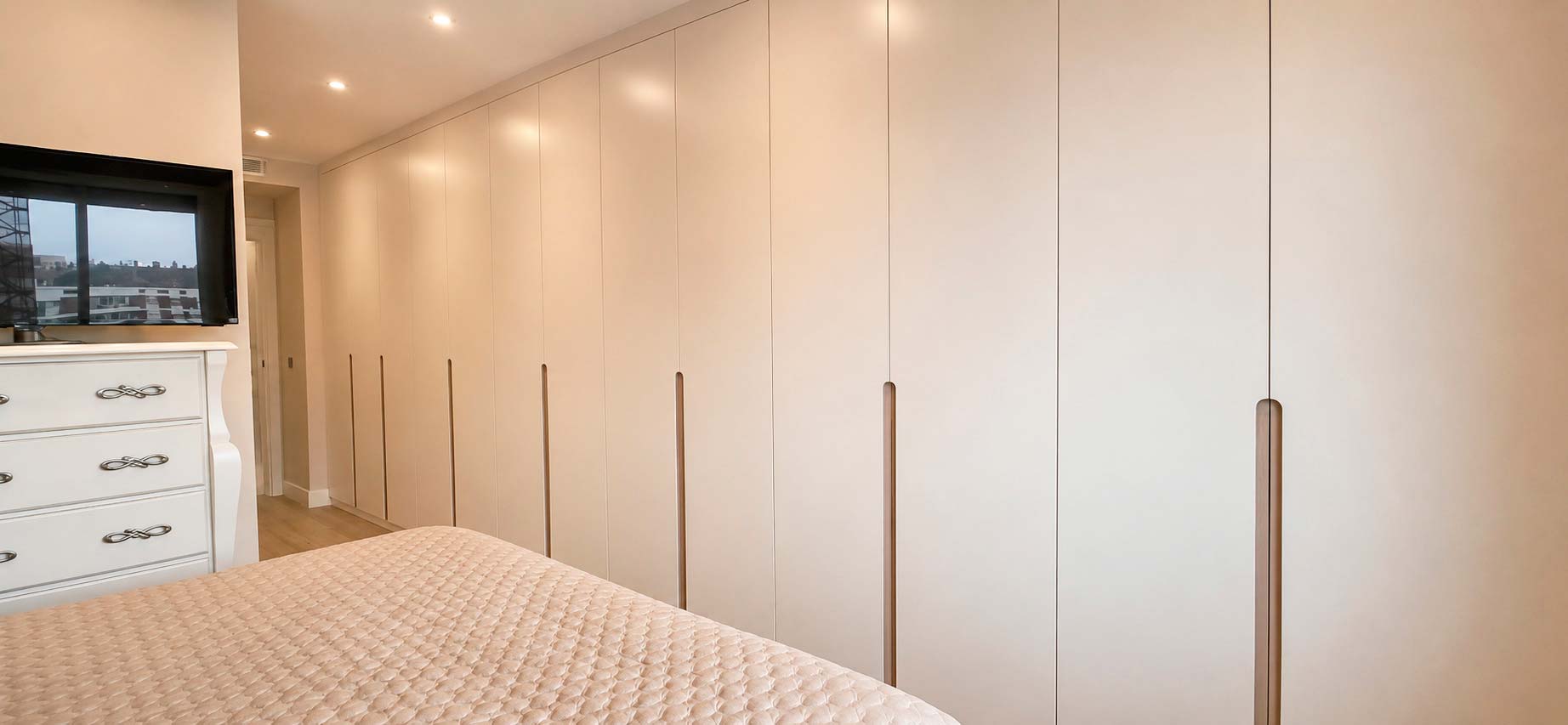 Armario de pared completa diseñado a medida en dormitorio principal del ático dúplex de calle Orense, Madrid