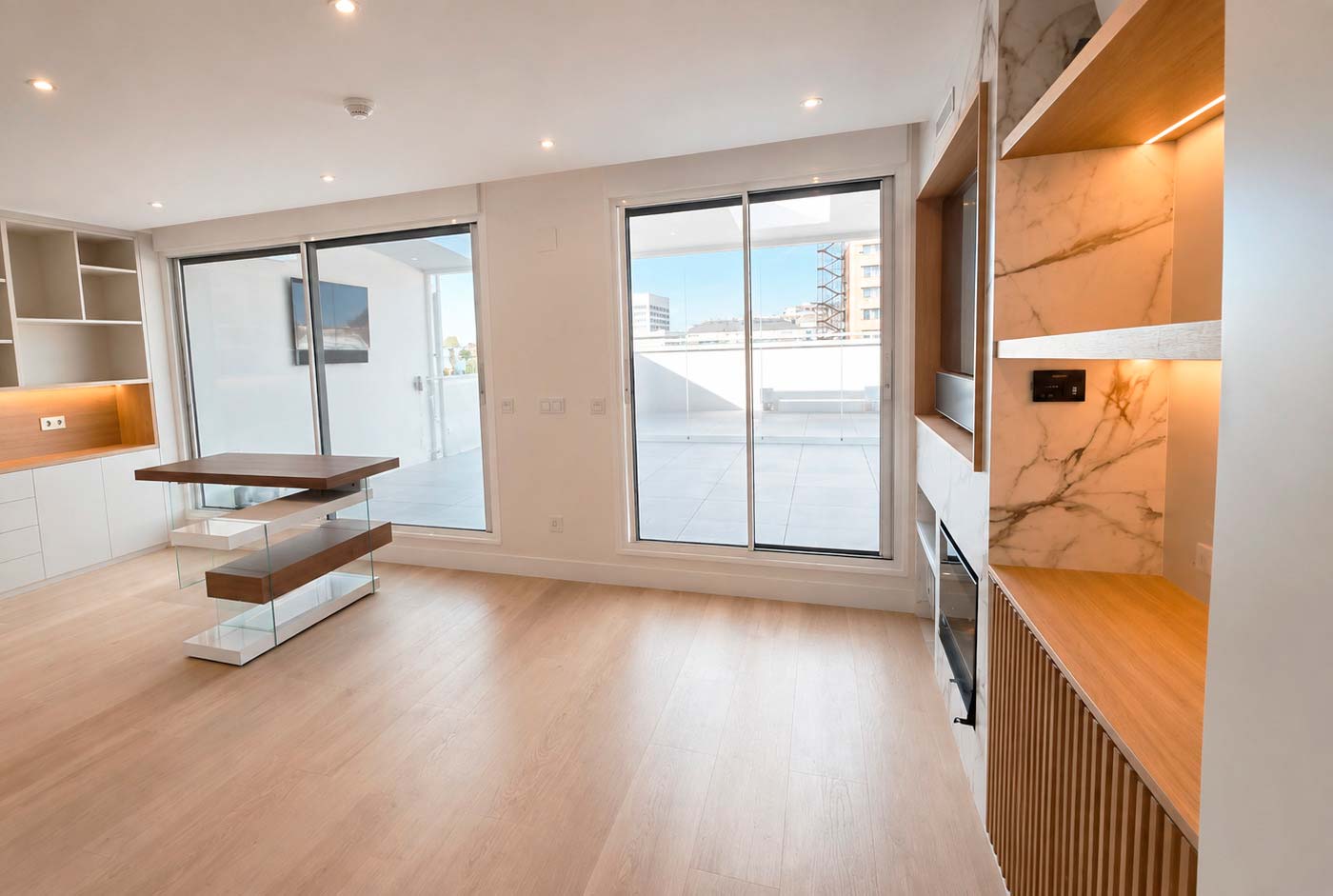 Zona de estar de la planta superior conectada visualmente con la terraza del ático dúplex reformado en calle Orense, Madrid