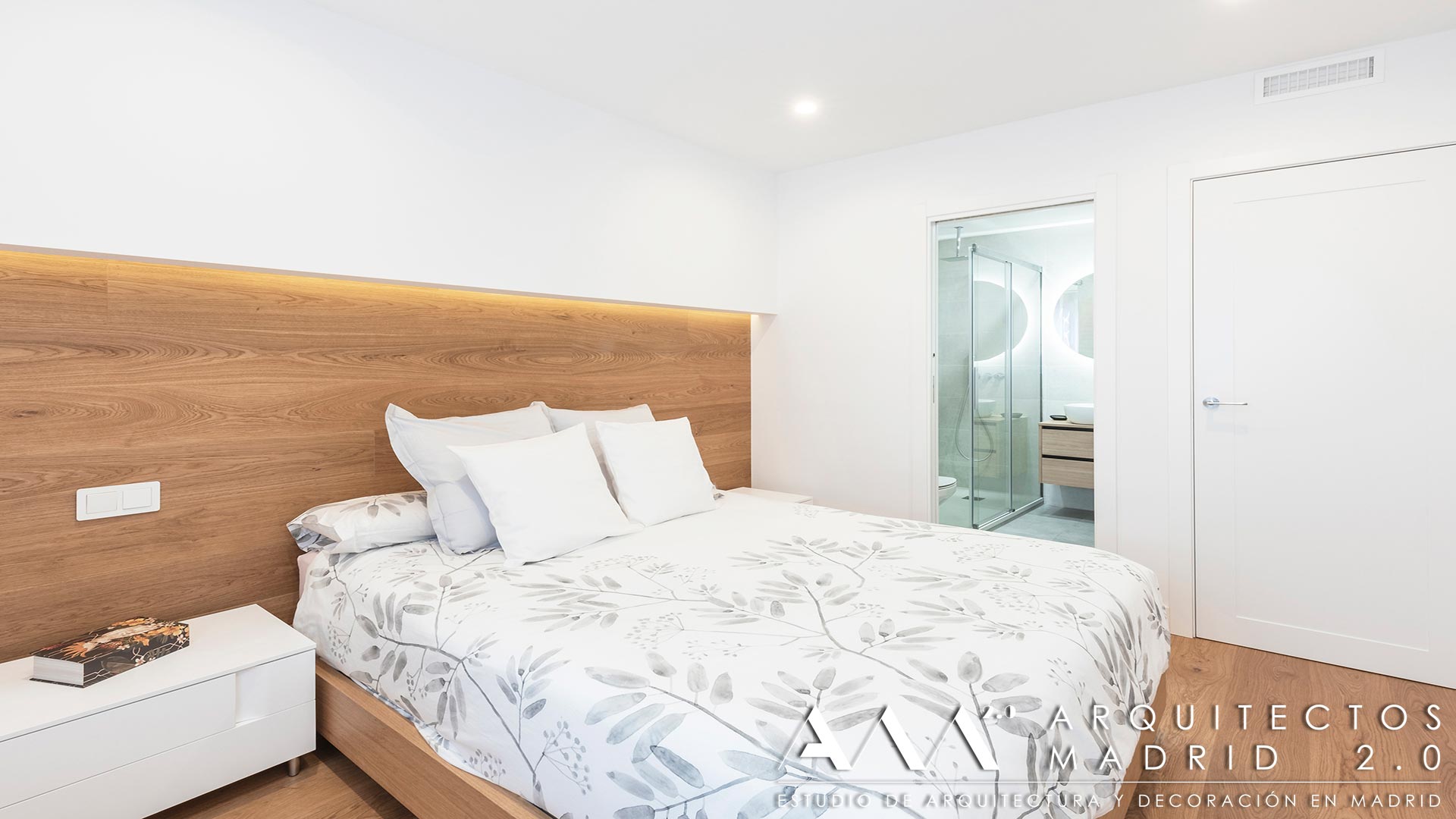 Dormitorio principal con cabecero de madera e iluminación indirecta tras la reforma integral de vivienda en Las Rosas, Madrid