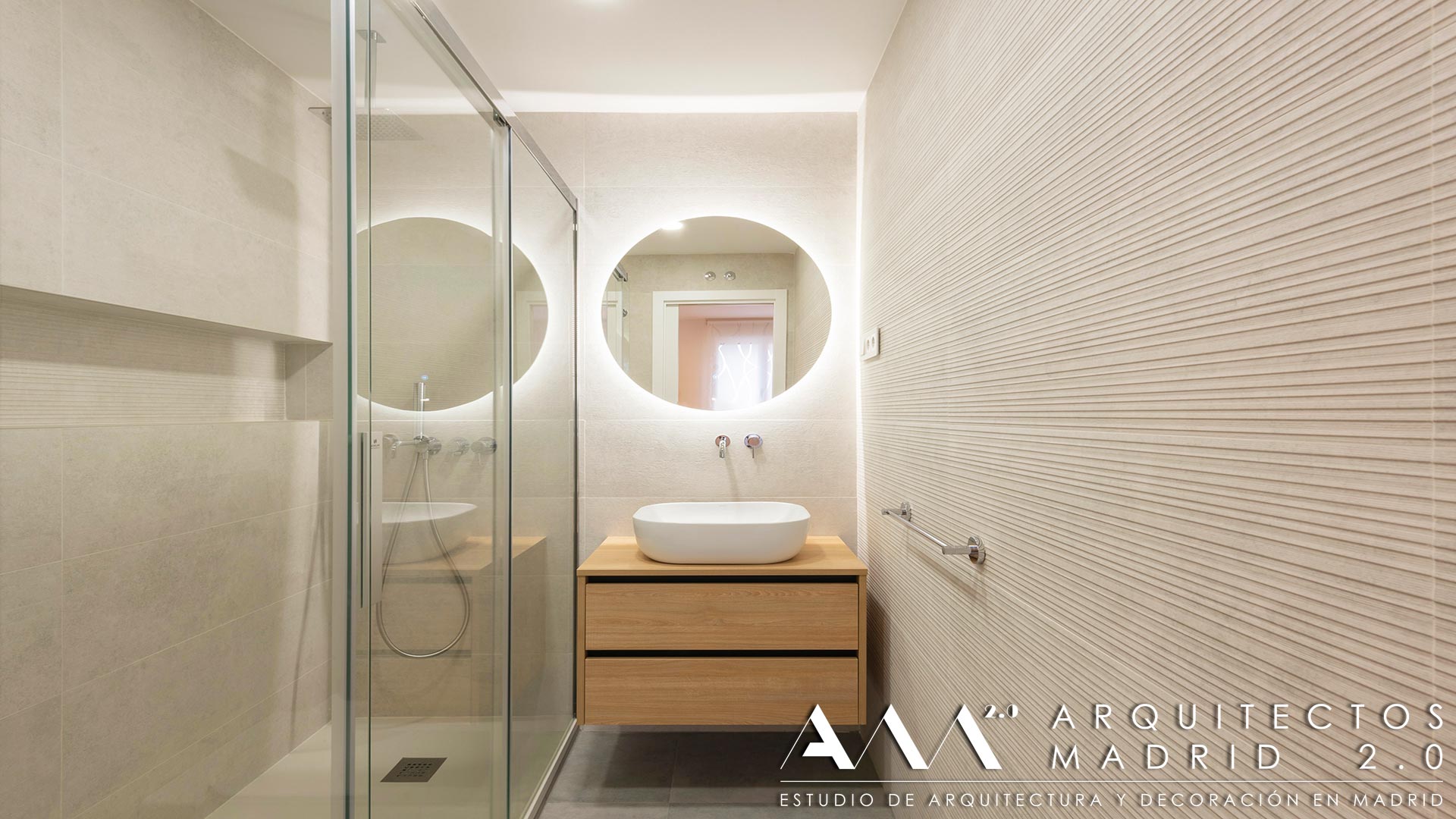 Baño reformado con ducha, mueble suspendido de madera y espejo retroiluminado en vivienda de Las Rosas, Madrid