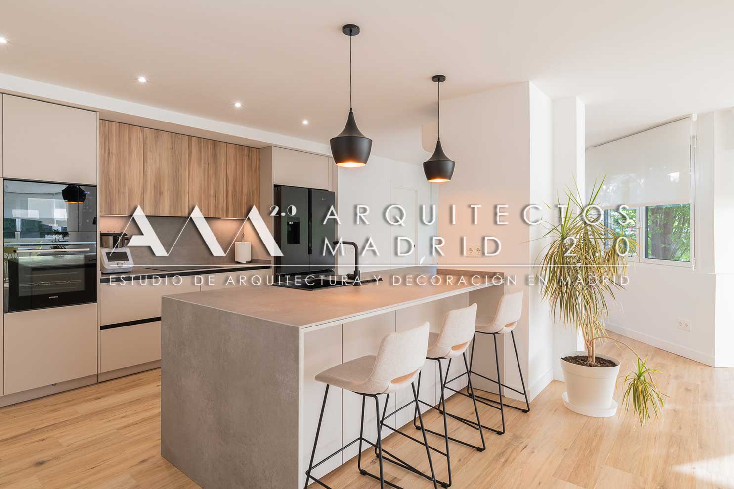 Cocina con isla de madera, horno integrado y columnas de almacenamiento en vivienda reformada en Chamartín
