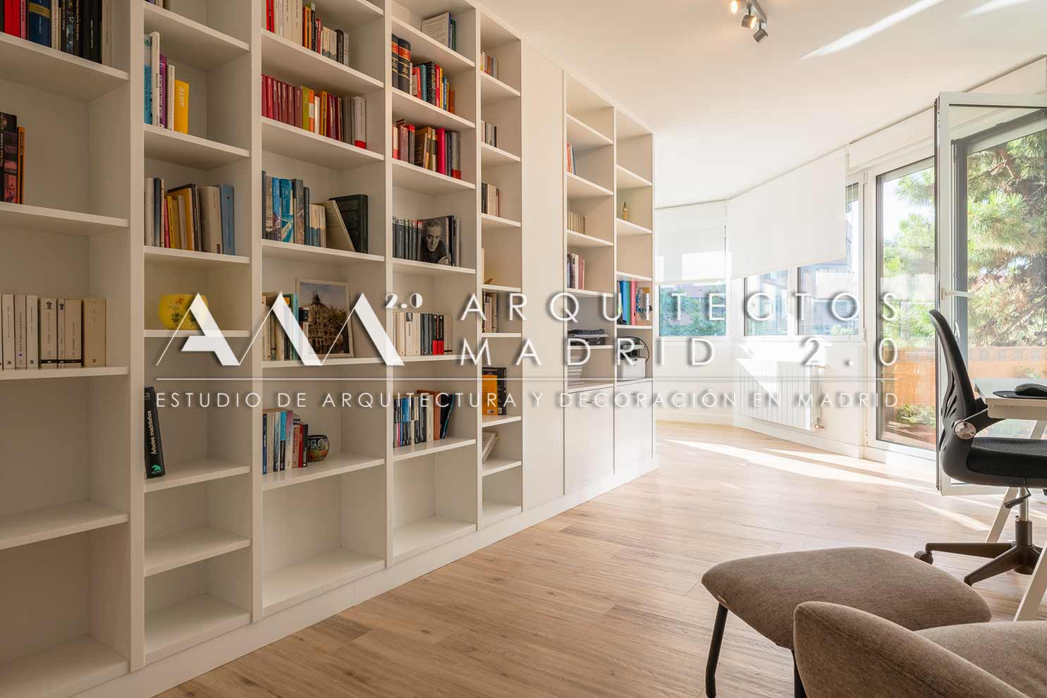 Biblioteca blanca a medida y despacho junto a los grandes ventanales en vivienda reformada en Nueva España, Chamartín