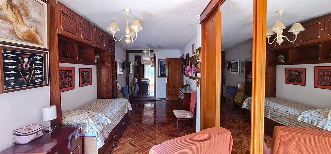 Estado previo de una estancia con carpinterías y muebles de madera oscura en vivienda de Chamartín