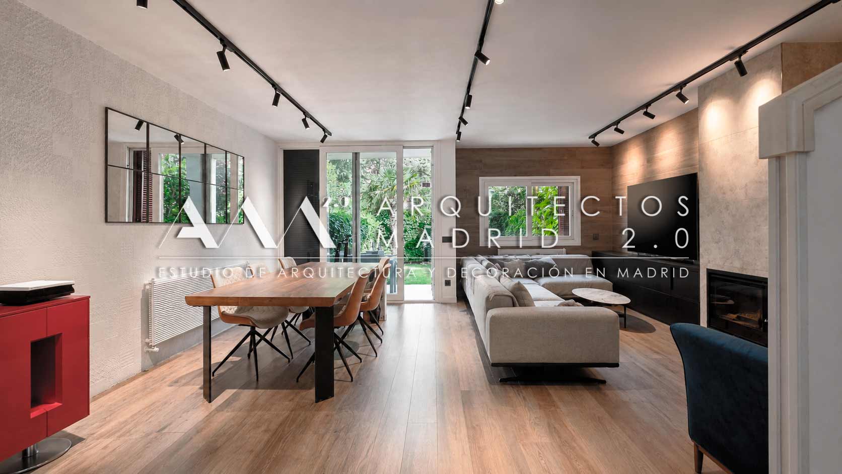 Salón con cocina abierta y chimenea en una vivienda familiar reformada