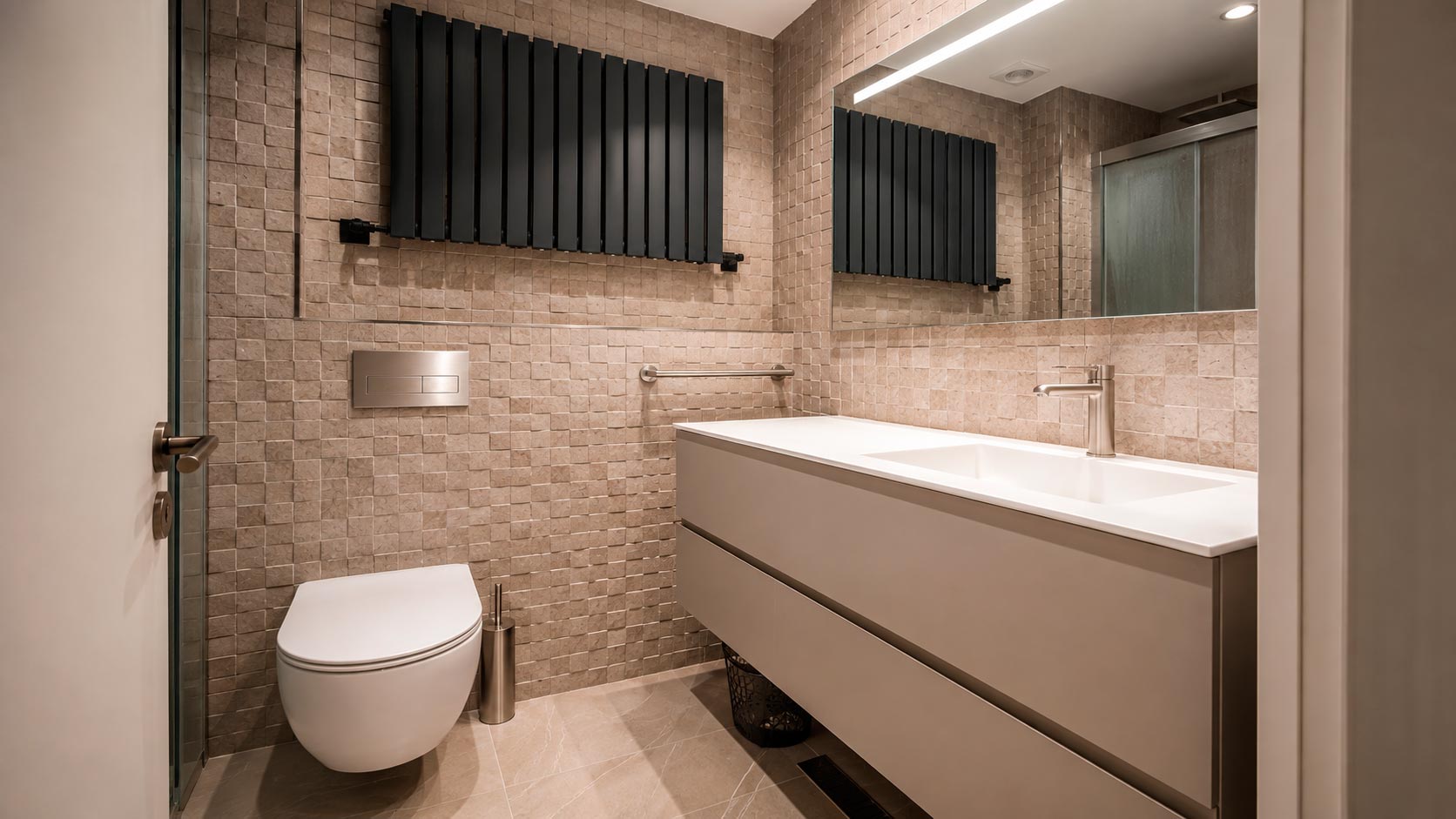Baño en suite con mueble suspendido, sanitario suspendido, gran espejo y radiador negro en reforma de Jorge Juan, Madrid