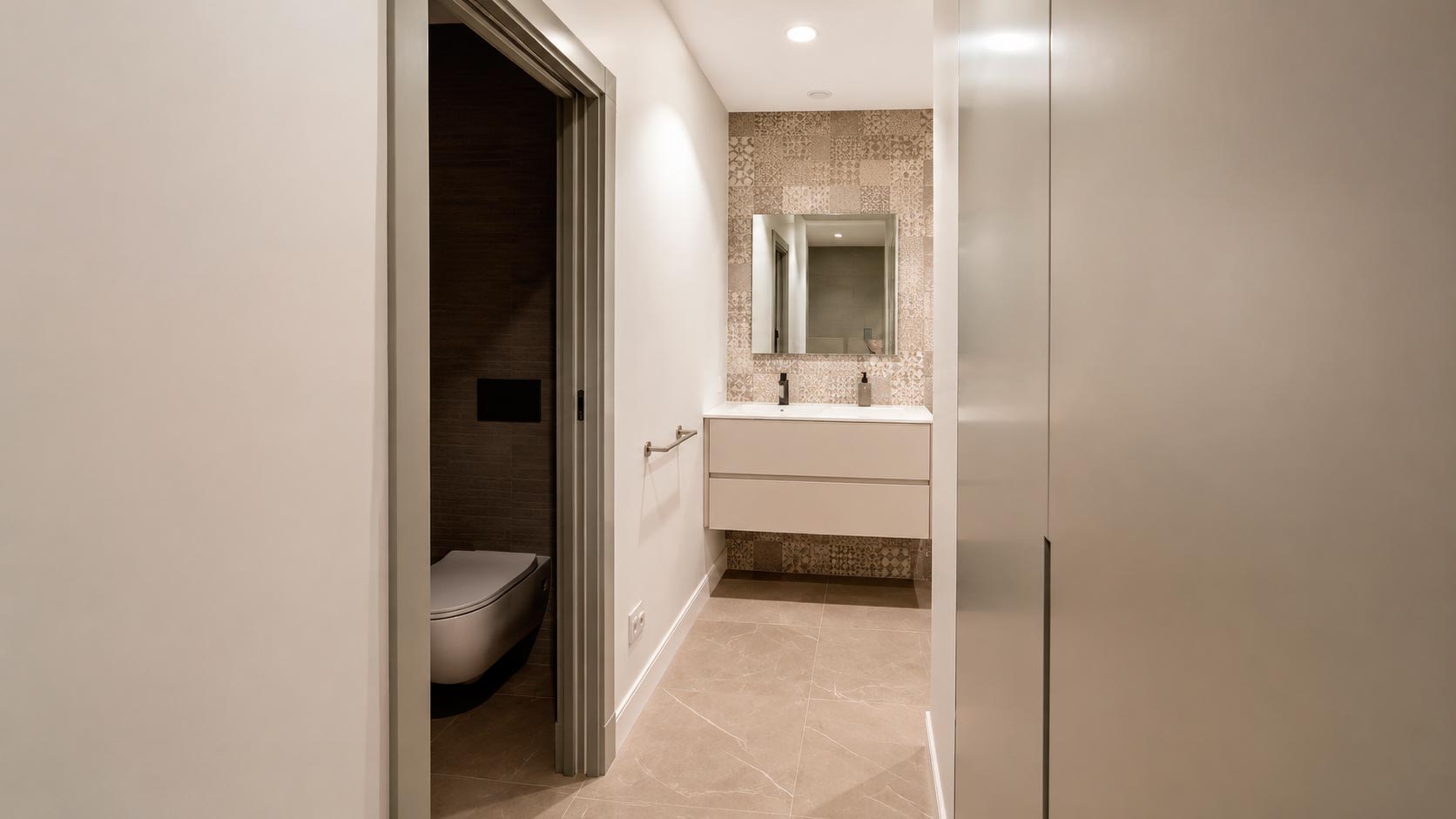 Acceso a baño y zona de lavabo desde el vestidor de una suite reformada en Jorge Juan, Madrid