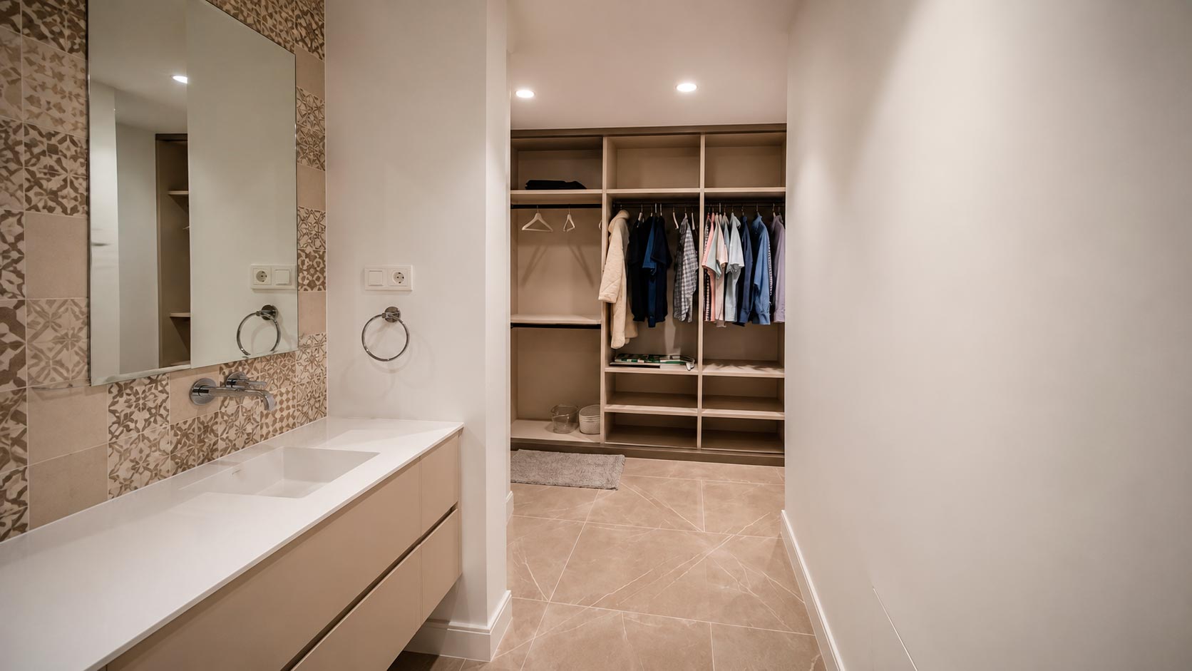 Secuencia entre lavabo, baño y vestidor de una suite reformada en vivienda de Jorge Juan, Barrio de Salamanca