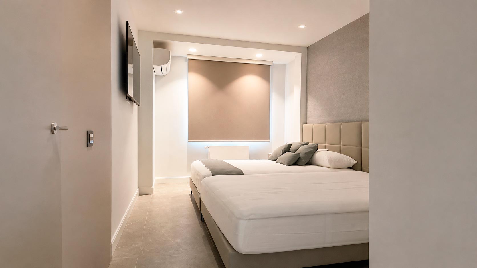 Dormitorio en suite con dos camas dobles de gran tamaño después de la reforma integral de vivienda en Jorge Juan, Barrio de Salamanca, Madrid