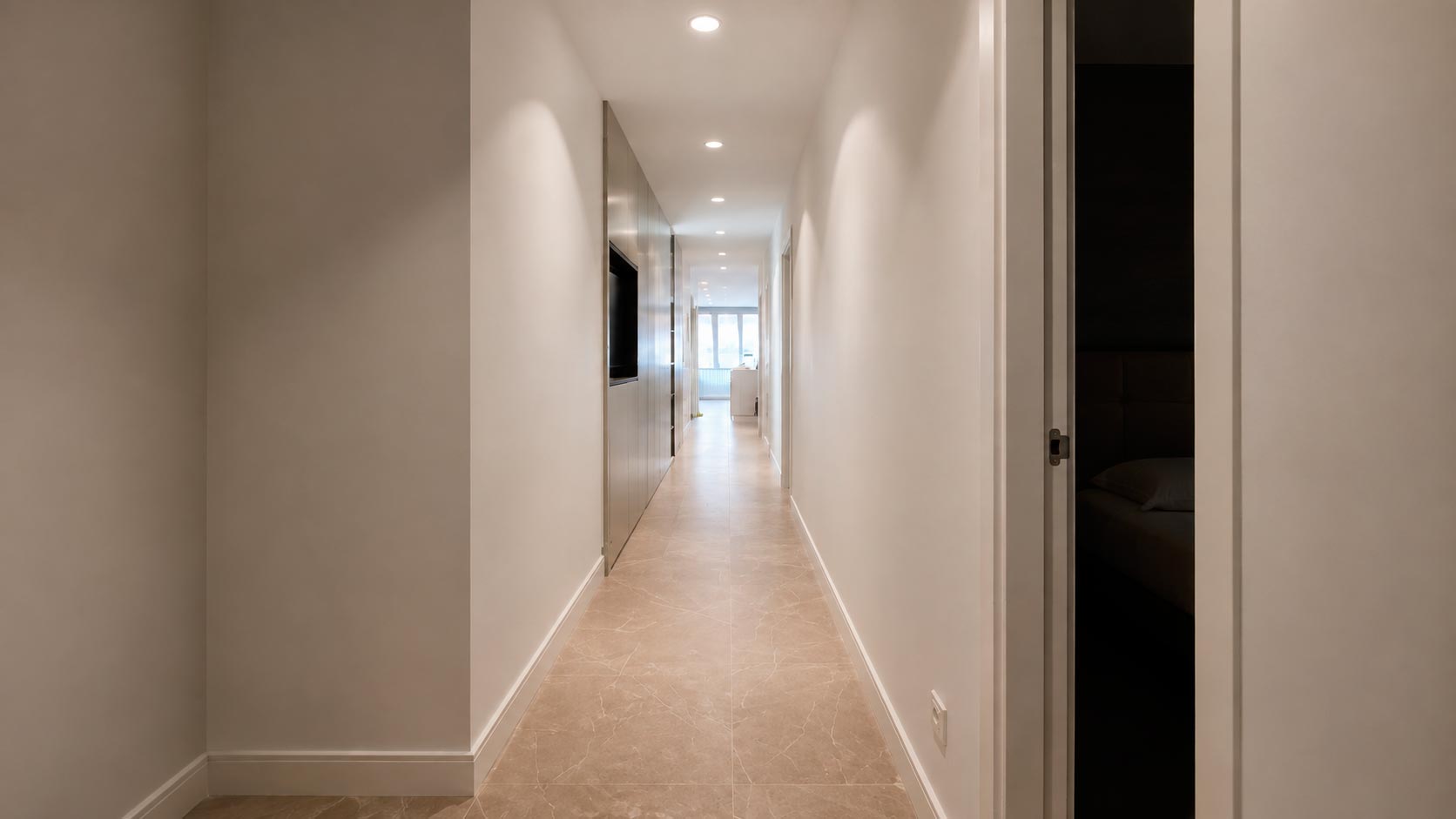 Distribuidor de la zona privada con grandes frentes de armarios integrados tras la reforma integral de vivienda en Jorge Juan, Barrio de Salamanca