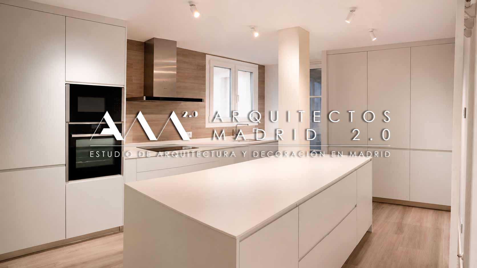 Cocina Emotions de Gamadecor con isla blanca y columnas de hornos en la reforma integral de un piso en Retiro, Madrid