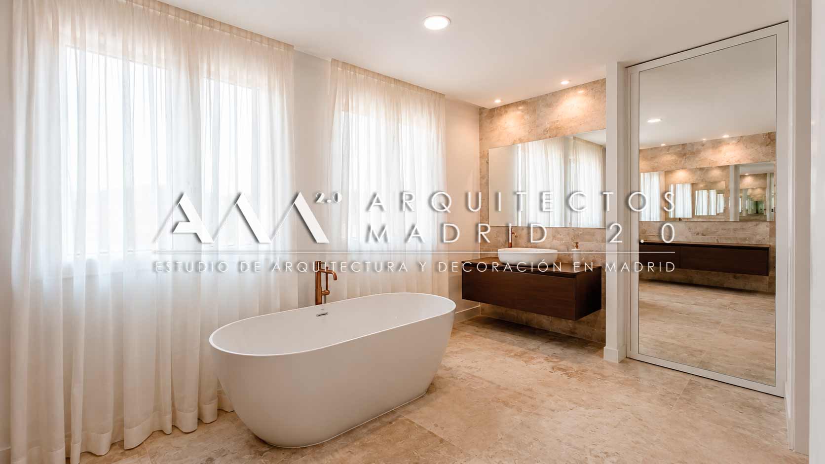 Baño en suite con bañera exenta y mobiliario de madera en un chalet reformado en Pozuelo