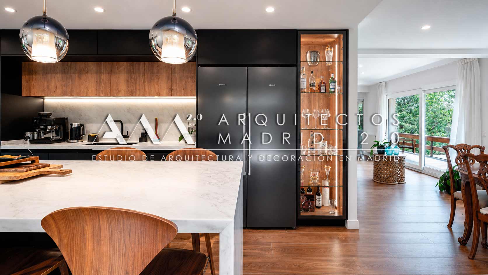 Cocina negra con isla curva y vitrina en reforma integral de chalet en Majadahonda