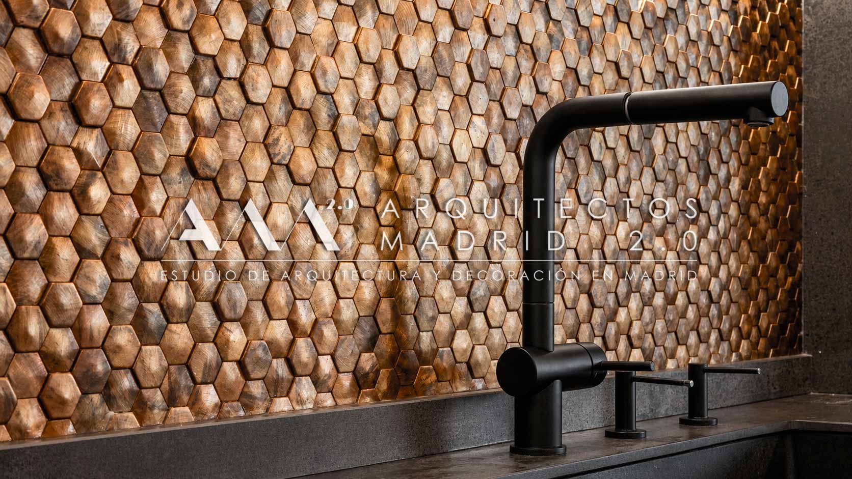 Detalle de cocina con grifería negra y revestimiento de mosaico en rehabilitación de vivienda unifamiliar