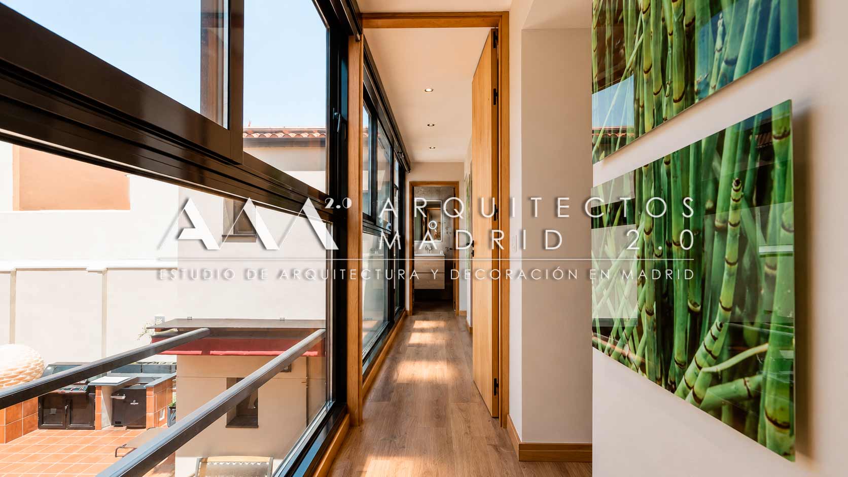 Galería interior con ventanales al patio y jardín vertical en vivienda unifamiliar rehabilitada