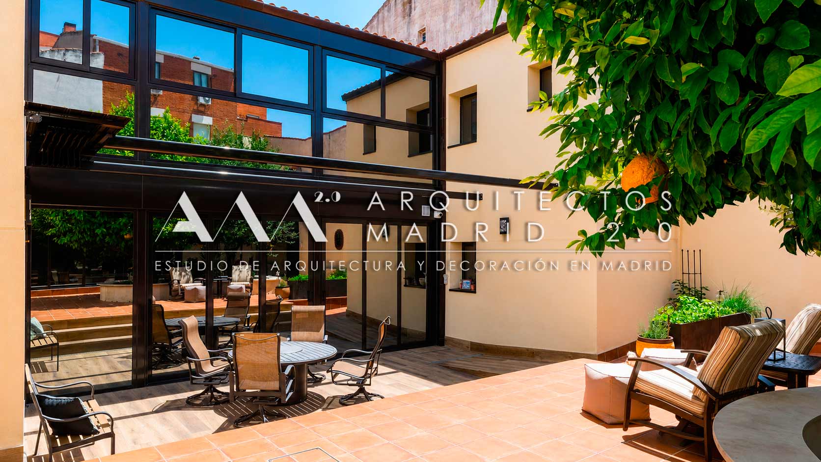 Patio interior de 131 metros cuadrados con terraza y gran galería acristalada negra tras la rehabilitación de vivienda unifamiliar en Madrid