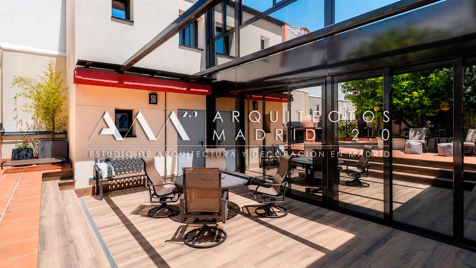 Terraza y patio con mobiliario exterior y gran cristalera negra en vivienda unifamiliar rehabilitada en Madrid